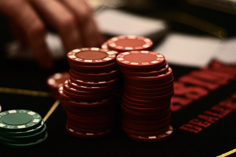 A player stacking casino chips at the table - the same “bonus funds” every offer in this guide ultimately becomes once you're playing with it. Photo by Jamie Adams, licensed CC BY-SA 2.0.